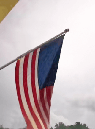 American Flag in a Storm in the background