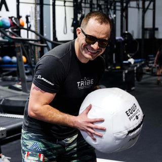 A Visually Impaired Man using an Equip - Dynamax White Wall ball standing in a gym