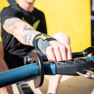 Black aluminum rowing hook on a concept2 rower handle with athlete rowing with one hand