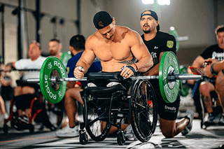 Mike Egan, CrossFit Games 2024, using the LapMat™ in a wheelchair with a barbell resting on the LapMat™