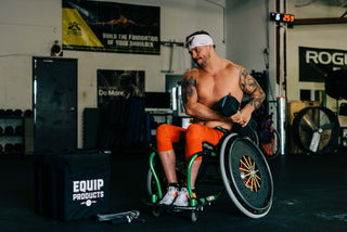 Jedidiah Snelson workout in his wheelchair with a dumbell, Multi Ropes™ on the floor, and The Package  waiting for him to use it in his workout