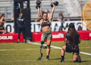 Amy Bream CrossFit Games 2023 On The Comp Field Lifting two Dumb bells over her head with her judge watching