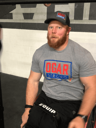 Kevin Ogar with a devilish grin staring at the camera in his gym in Colorado