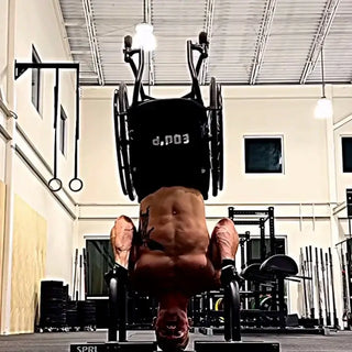 Man in wheelchair doing headstand with Equip Body Strap