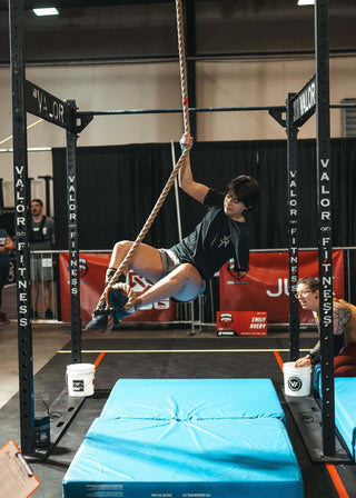 Emily Avery, who lost an arm in an accident, climbing a rope in the 2023 WheelWOD Games