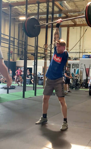 Logan Aldridge picture of him doing an iconic lift with one hand holding a barbell with at least 225 pounds on it, in Collinwood Ontario Canada