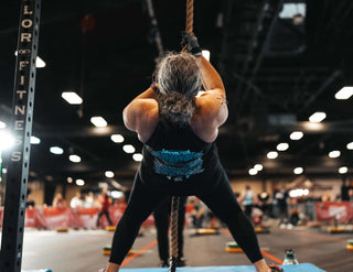 Susan Gilson starting a rope climb at the 2023 WheelWOD Games