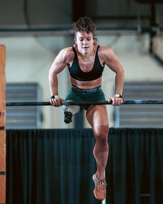 Amy Bream - CrossFit Athlete doing a bar muscle up