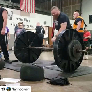 James Spurgin doing a deadlift with what looks like giant train wheels weighing about 650 pounds