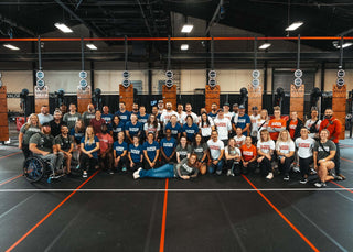 Vounteers at the 2023 WheelWOD Games posing for a picture on the floor in front of the rig.