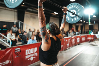 Neuro Female Athlete Holding Barbell With Bumper Plates Over Her Head.