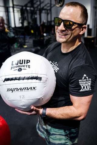 A Visually Impaired Man holding an Equip - Dynamax White Wall ball.