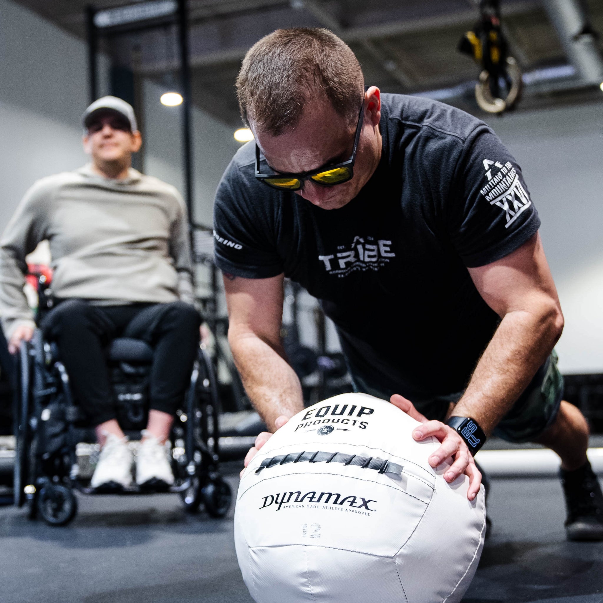 A Visually Impaired Man on how knees leaning on an Equip - Dynamax White Wall ball in a gym