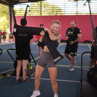 Lady Dropping the 60 Pound Equip Products CrossCarry Sandbag after a shuttle run smiling