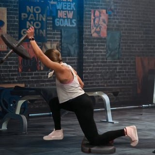 Person exercising in a gym with motivational posters on the wall.