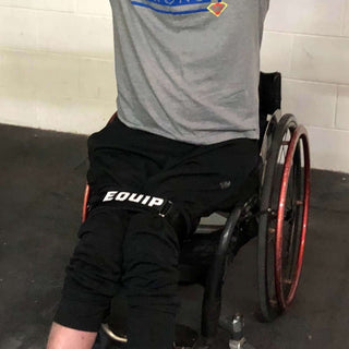 Leg Strap Picture of Wheelchair users with legs tightened in the strap getting ready to do pull-ups