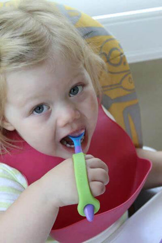 Child using EazyHold Teacher & Therapist 7-Pack grip aid to eat comfortably in a high chair.