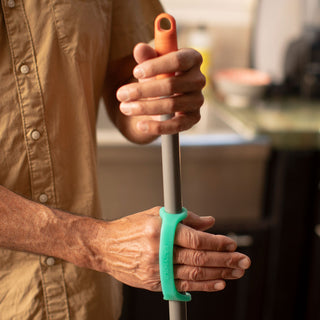 EazyHold Teacher & Therapist 7-Pack used by a person holding a mop using a silicone cuff grip aid.