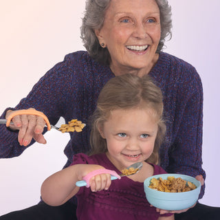 EazyHold Teacher & Therapist 7-Pack in use with an elderly woman and a young girl enjoying cereal together.