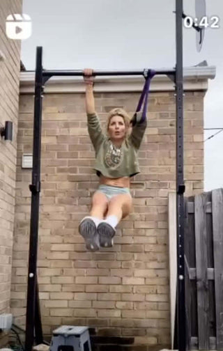 Louise Hawkins using the LouP strap on a pull up rig outside