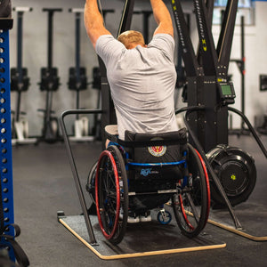 Wheelchair Athlete Kevin Ogar Using a Concept2 Ski Erg with his back facing you in a gym setting equip wider base