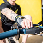 Black aluminum rowing hook on a concept2 rower handle with athlete rowing with one hand